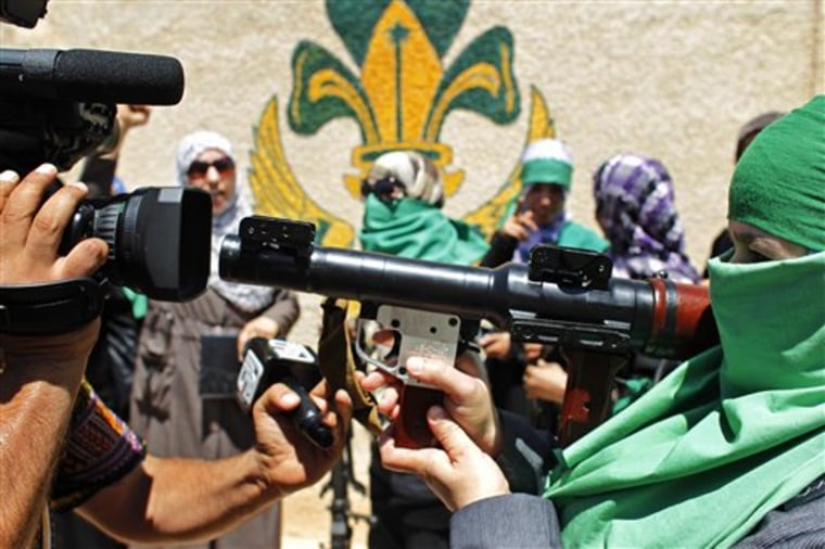 A journalist photographs a Libyan woman as she points her weapon at the video camera in the town of Gharyan, 62 miles southwest of Tripoli, Libya, on Sunday. Moammar Gadhafi's regime is seeking to show it remains in control of parts of the country's western mountains and will defend the territory against further rebel advances there. Journalists based in Gadhafi's stronghold of Tripoli were taken Sunday to the mountain gateway town of al-Gharyan and the nearby town of al-Assabaa. 